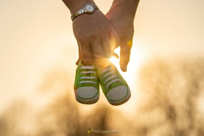 Eine Person, die ein Paar Babyschuhe hält