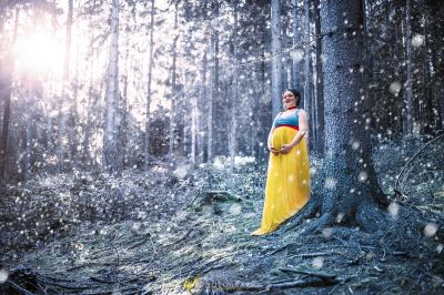 Eine Frau in einem gelben Kleid, das im Wald steht