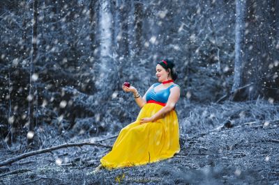 Eine Frau in einem gelben Kleid hält einen roten Apfel