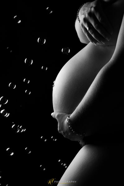 Eine schwangere Frau steht im Regen