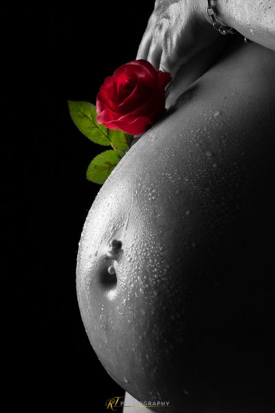 Der Bauch einer Frau mit einer Rose im Bauch