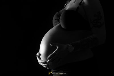 Eine schwangere Frau mit einem Tattoo auf ihrem Bauch