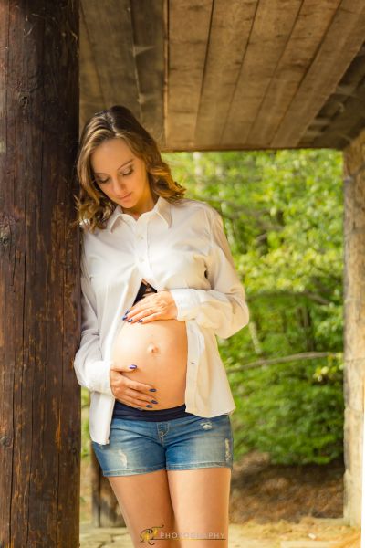 Eine schwangere Frau, die in einer hölzernen Struktur steht