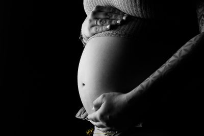 Eine schwangere Frau hält ihren Bauch