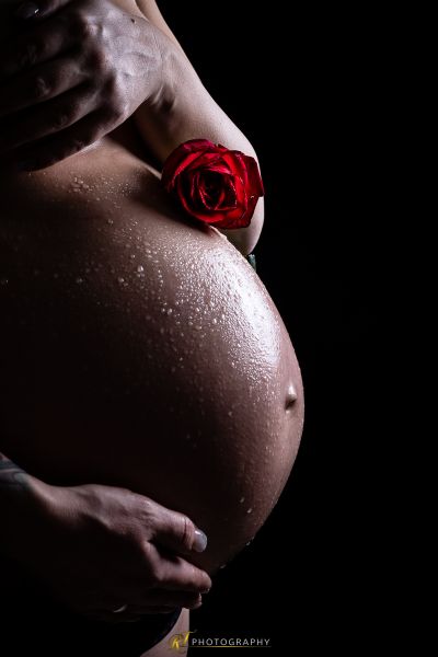 Eine Frau, die eine Rose in ihrem Bauch hält