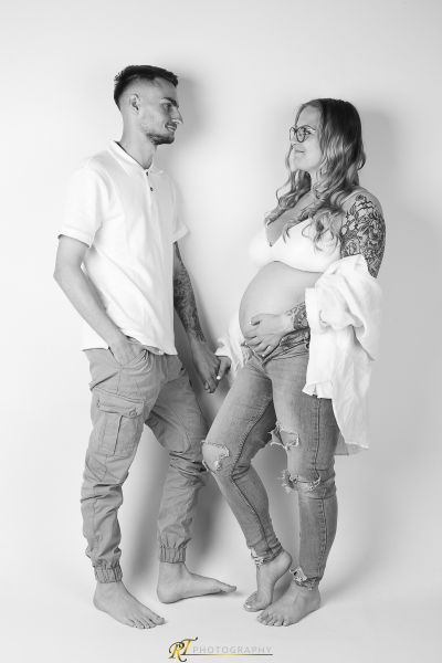 Ein schwangeres Paar posiert für ein Mutterschaftsfoto