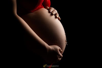 Eine Frau in einem roten BH mit einem Perlenarmband