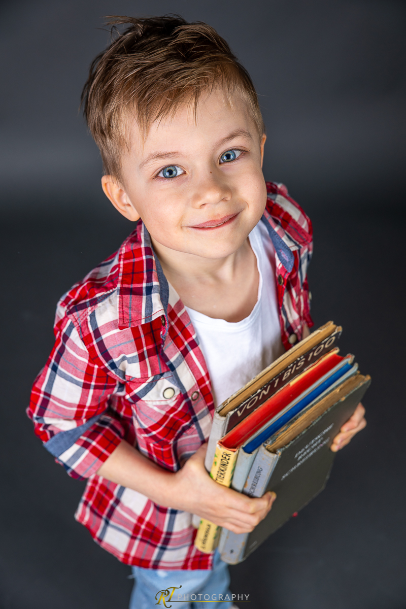 Ein kleiner Junge, der ein Buch hält und lächelt