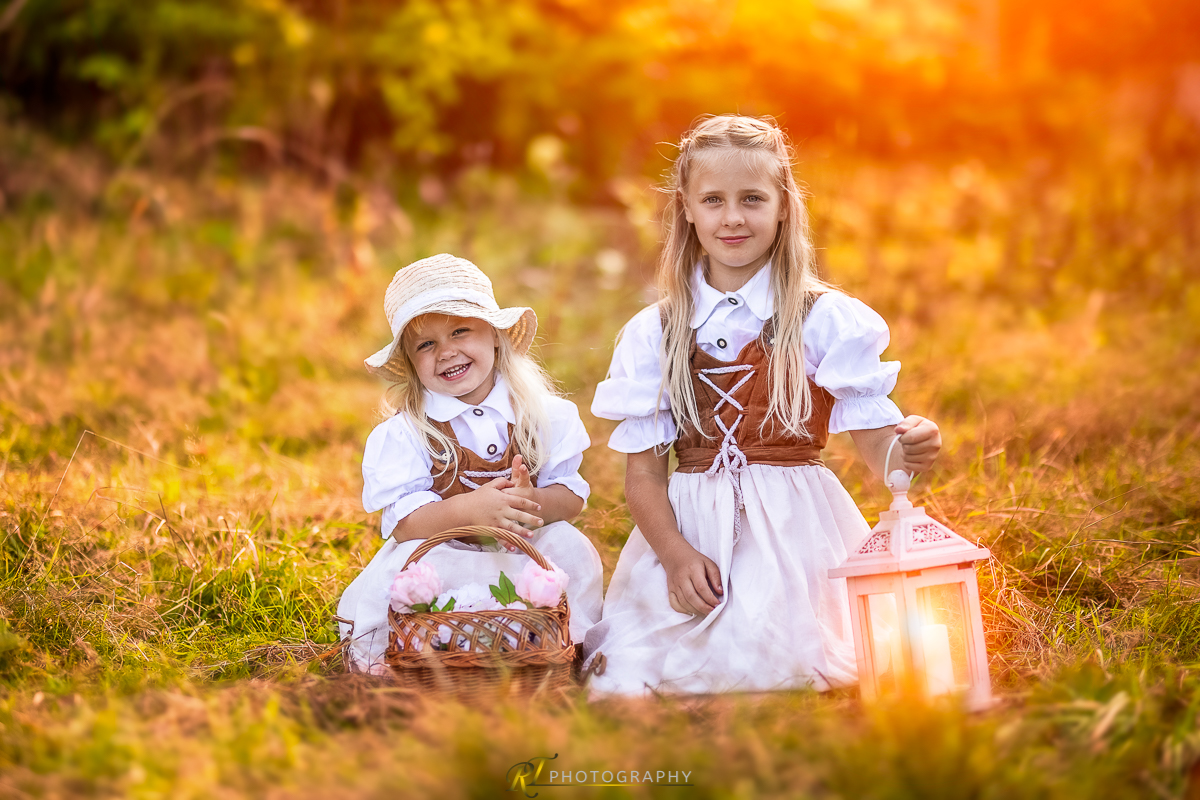 Zwei kleine Mädchen sitzen im Gras