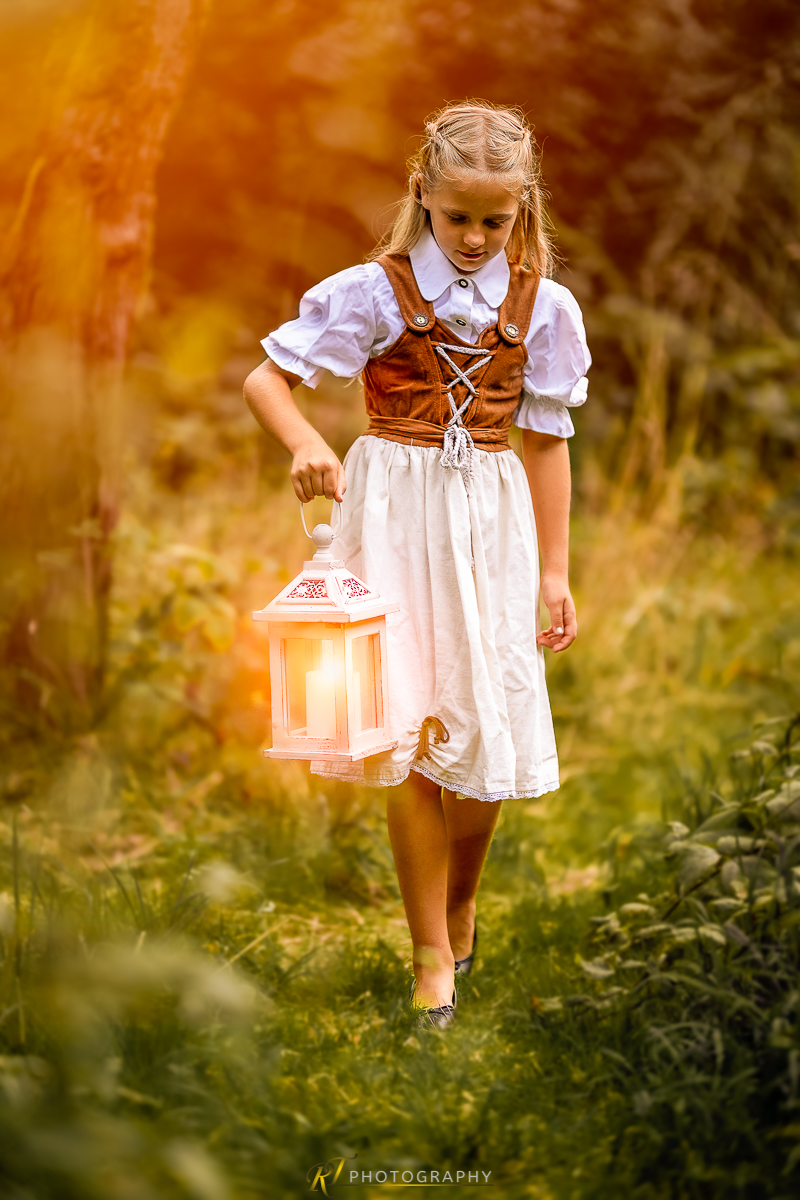 Ein kleines Mädchen in einem weißen Kleid mit einer Laterne