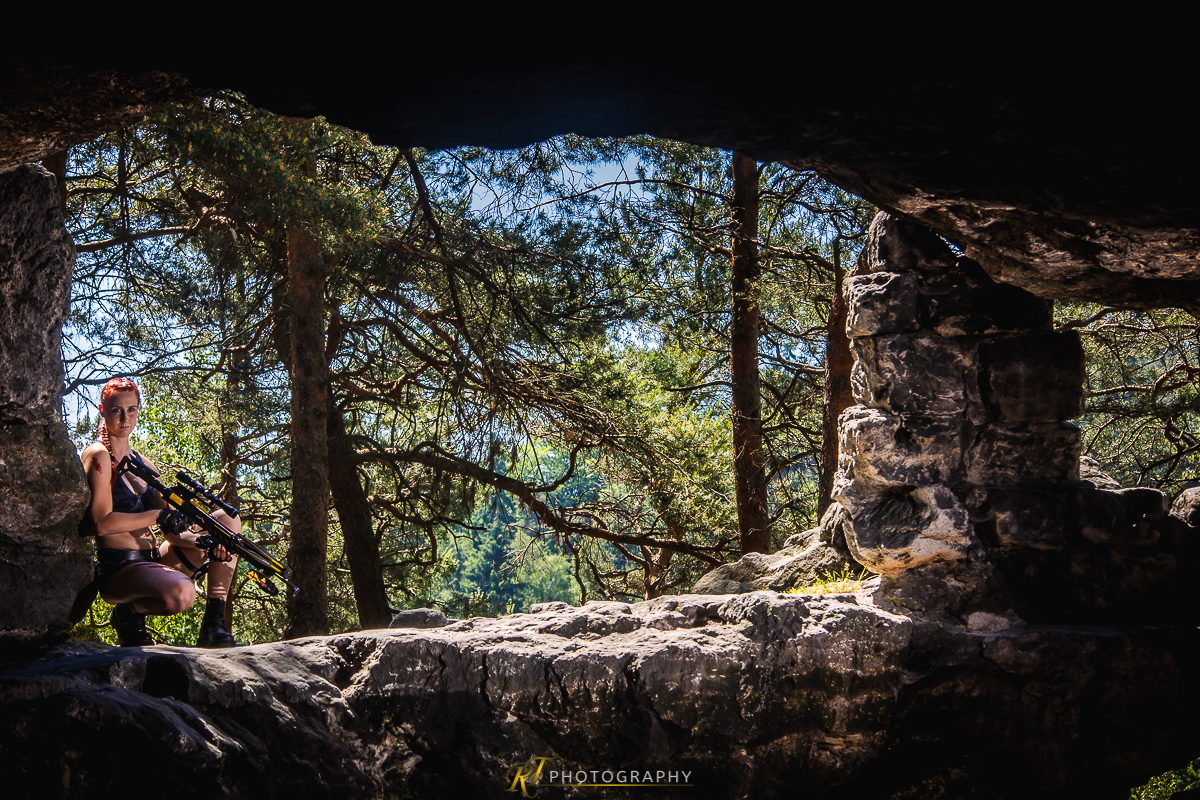 Eine Frau, die auf einem Felsen in einem Wald sitzt