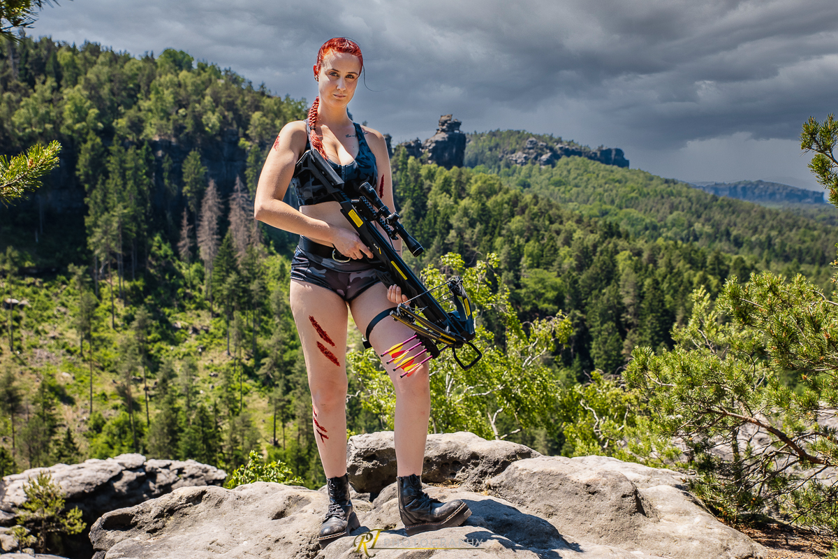 Eine Frau mit einer Waffe auf einem Felsen